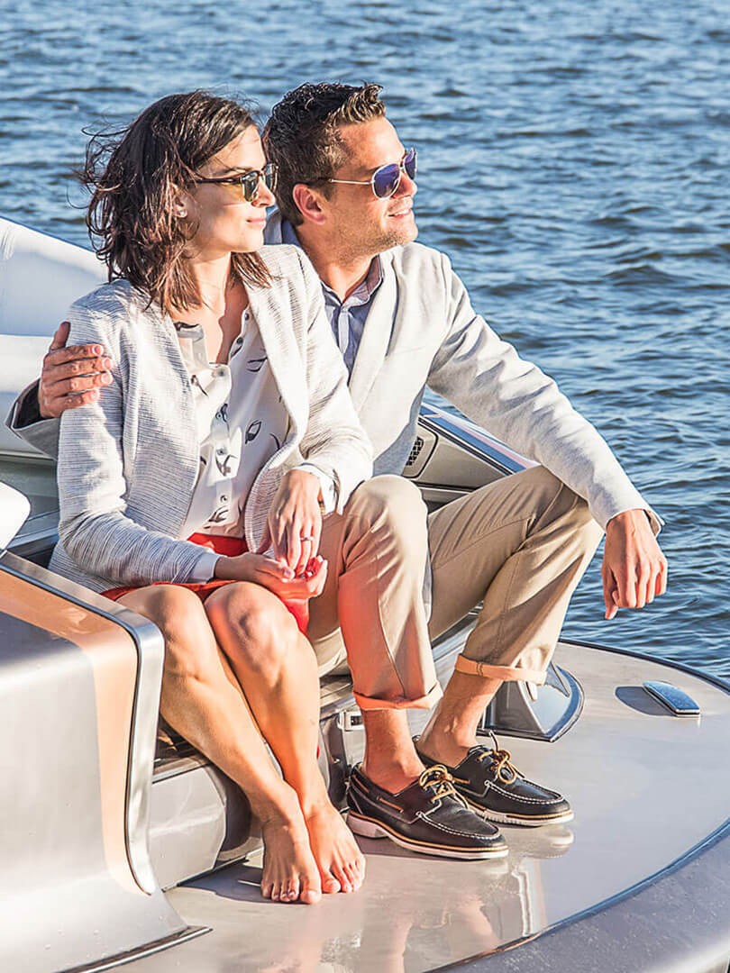 Мъж и жена гледащи слънцето от спортната яхта на Lexus
